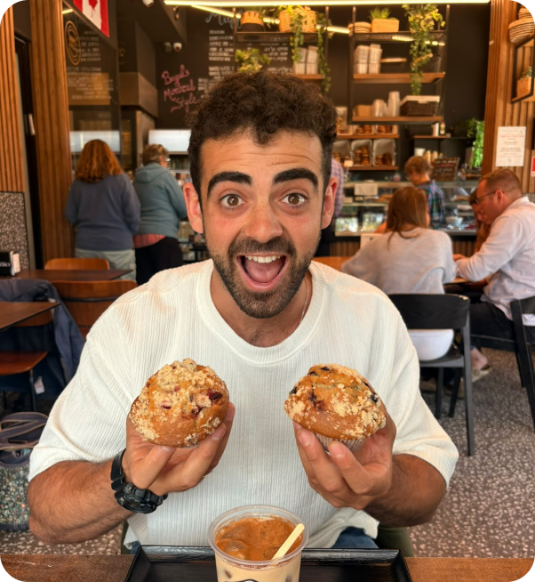 Yona Shemesh in a Jerusalem bakery holding two fresh pastries