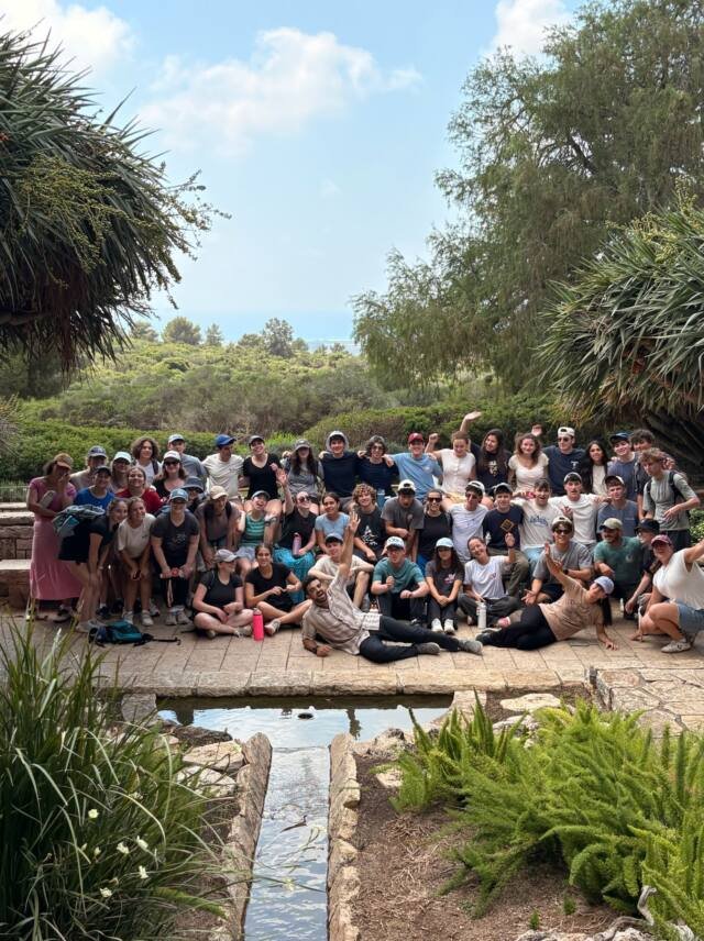 A large group gathered in a garden on tour