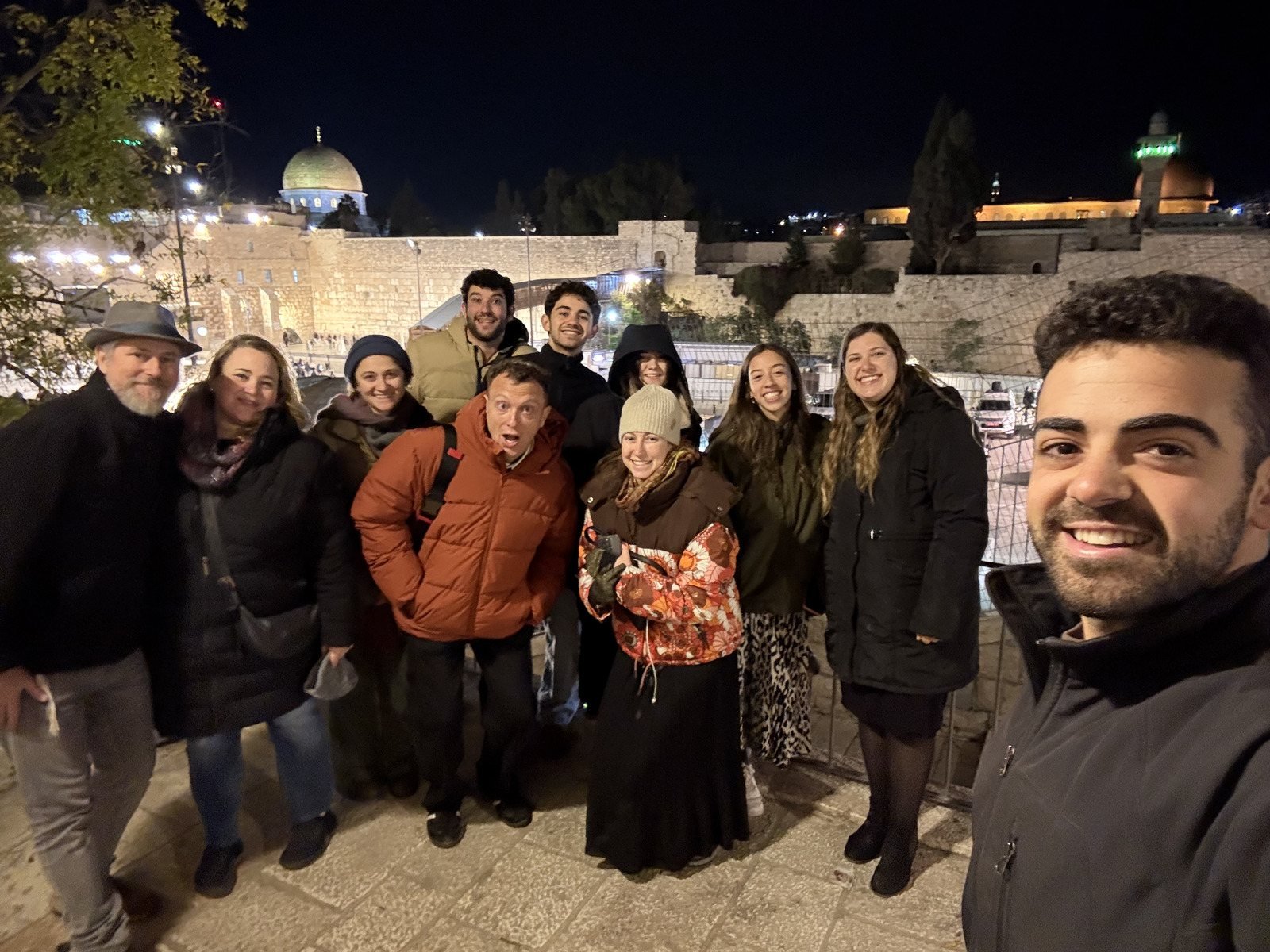 An evening tour group above the lit Old City of Jerusalem