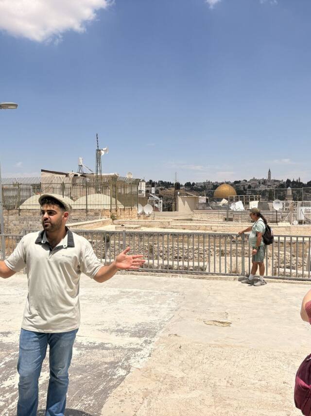 Yona Shemesh on an Old City rooftop with the Dome of the Rock behind him