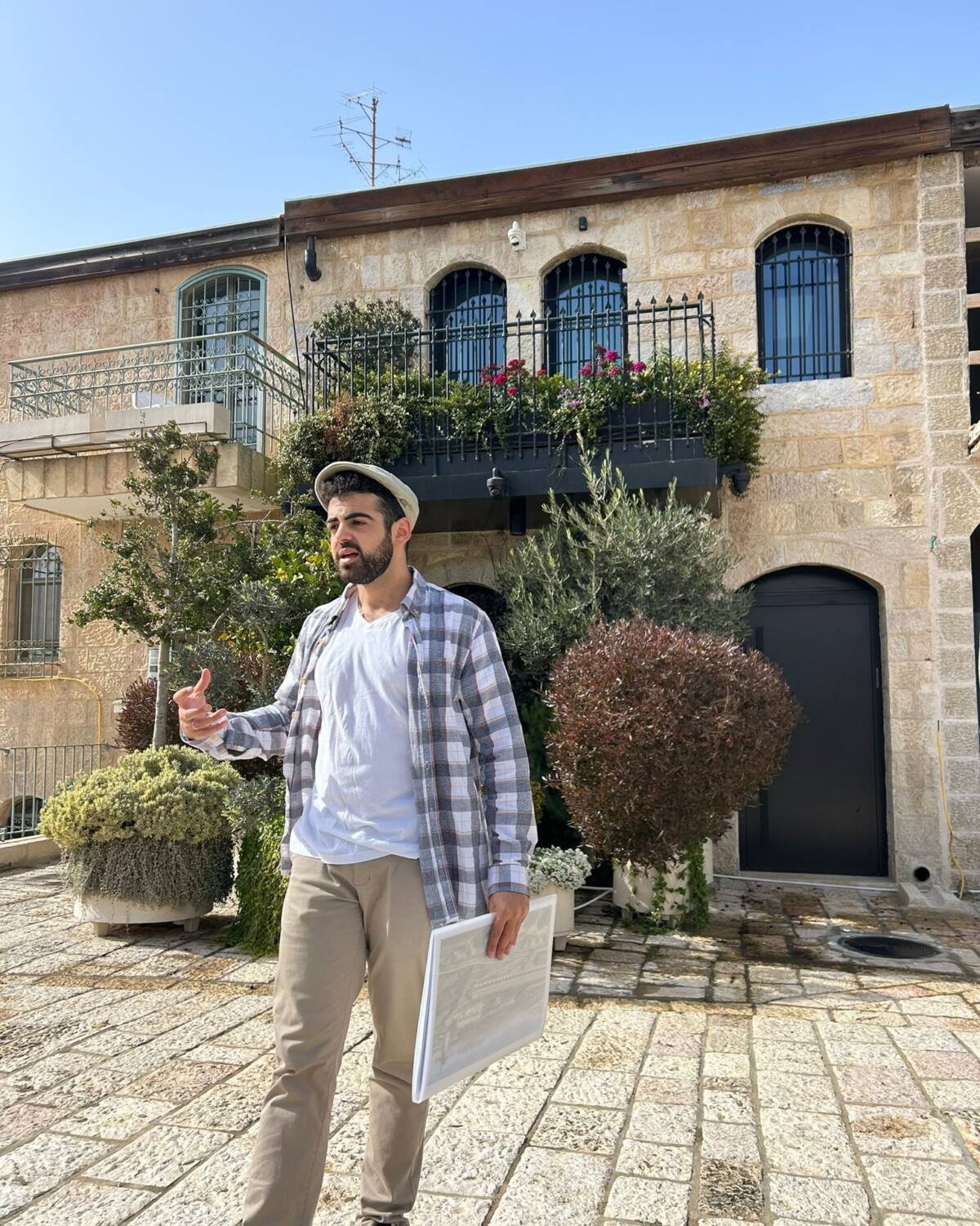 Yona Shemesh introducing a tour in a Jerusalem courtyard