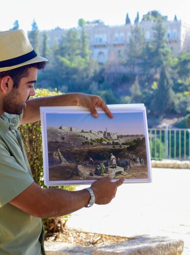 Yona Shemesh comparing a historic photograph with the view over Jerusalem