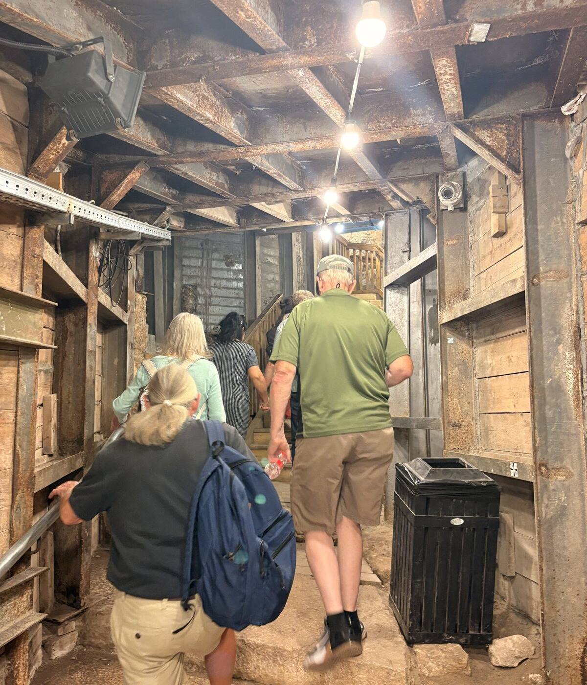 Visitors walking the timber-shored passage of the Western Wall Tunnels